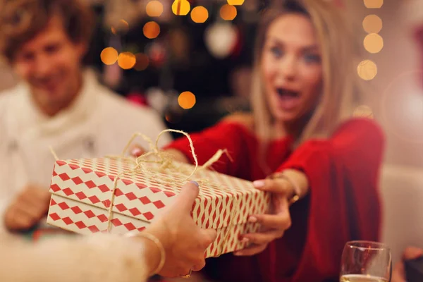 Grupp av vänner som ger jul presenterar hemma — Stockfoto