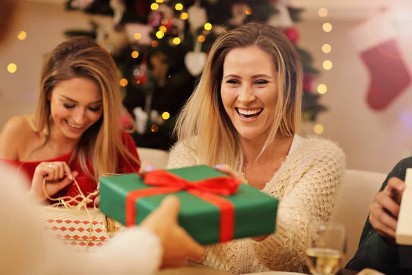 Grupo de amigos dando presentes de Natal em casa — Fotografia de Stock