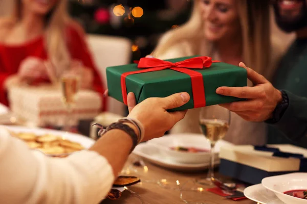 Grupo de amigos dando presentes de Natal em casa — Fotografia de Stock