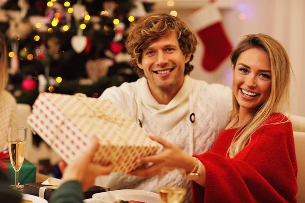 Group of friends giving Christmas presents at home — Stock Photo, Image