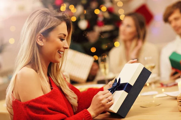 Grupo de amigos dando presentes de Natal em casa — Fotografia de Stock