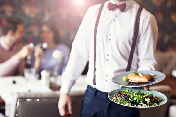 Romantische paar dating in restaurant wordt geserveerd door ober — Stockfoto