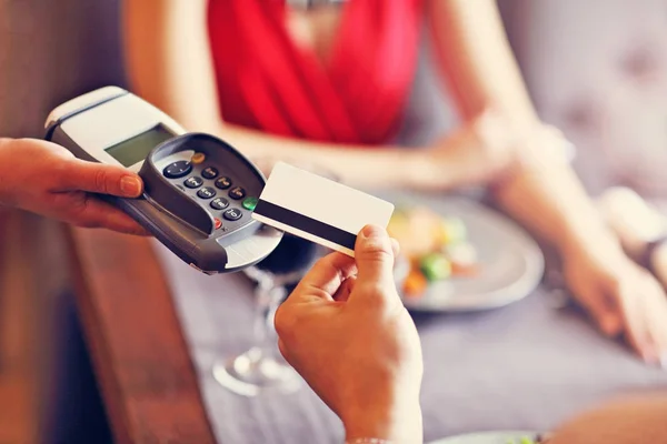 Människor som betalar i restaurangen av kreditkortsläsare — Stockfoto
