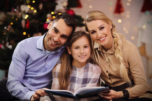 크리스마스 트리 아래 함께 이야기 책을 읽고 가족 — 스톡 사진