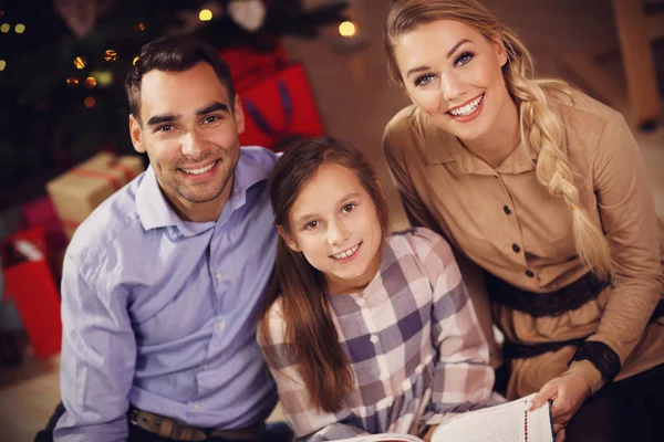 Familie verhaal boek samen lezen onder kerstboom — Stockfoto