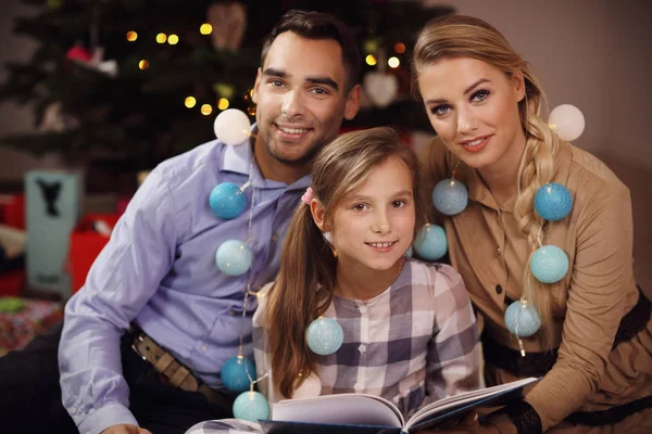 Livro de história de leitura da família juntos sob a árvore de Natal — Fotografia de Stock