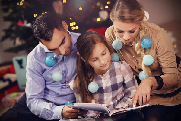 Livro de história de leitura da família juntos sob a árvore de Natal — Fotografia de Stock