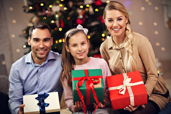 Família feliz se divertindo com presentes durante o Natal — Fotografia de Stock