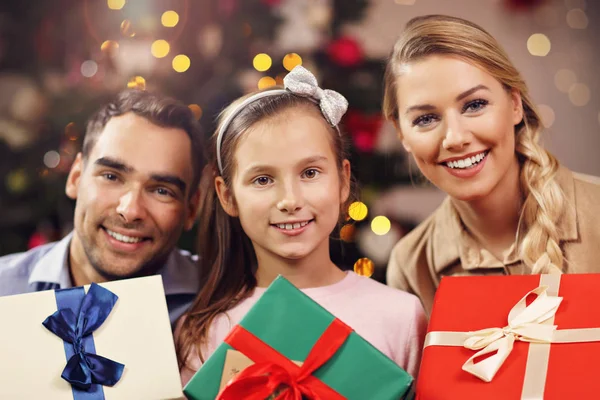 Familia feliz divirtiéndose con regalos durante la Navidad — Foto de Stock