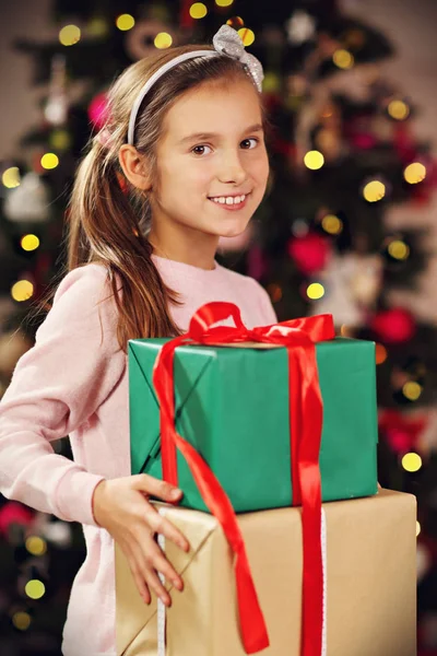 Menina feliz posando com presentes durante o Natal — Fotografia de Stock
