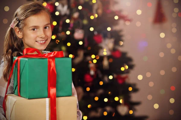 Chica feliz posando con regalos durante la Navidad —  Fotos de Stock