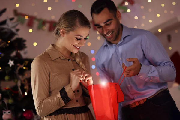 Счастливая пара открывает рождественский подарок — стоковое фото