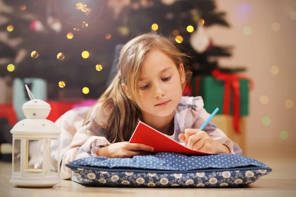 Счастливая девочка пишет рождественское письмо Санта-Клаусу — стоковое фото