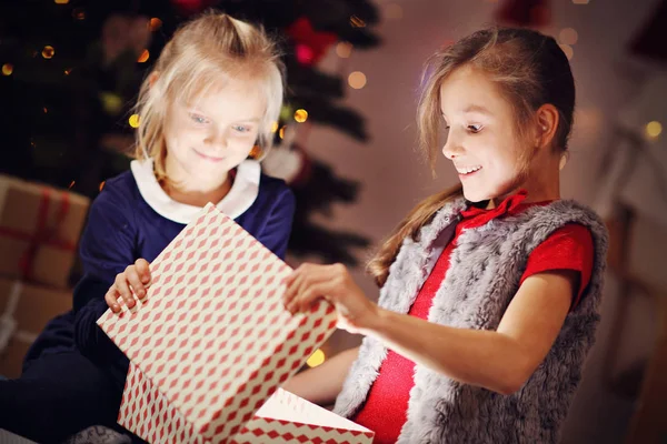 Gelukkige kinderen openen kerstcadeau Stockafbeelding