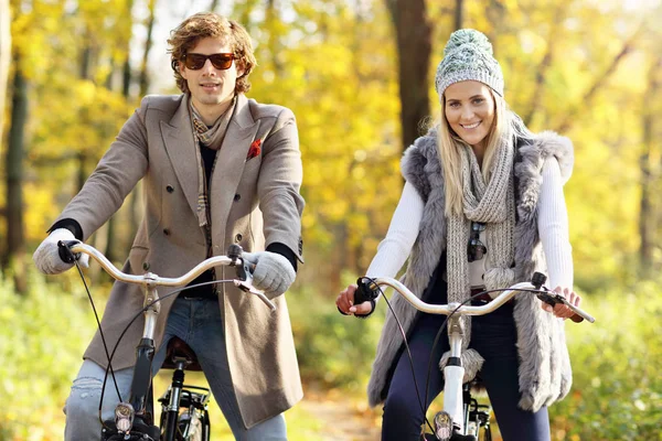 Casal feliz em bicicletas na floresta durante o outono — Fotografia de Stock