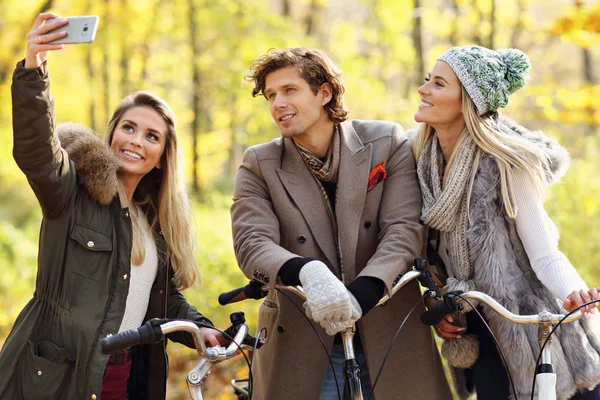 Gruppo di amici in bicicletta nella foresta durante l'autunno — Foto Stock