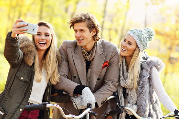 Grupp vänner på cyklar i skogen under faller gång — Stockfoto