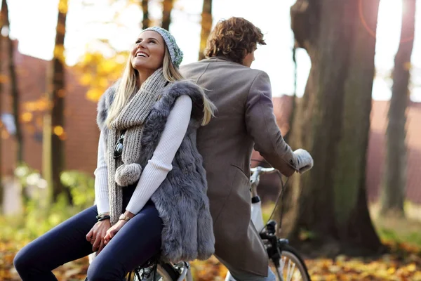 Gelukkige paar op fietsen in het bos tijdens de val tijd — Stockfoto