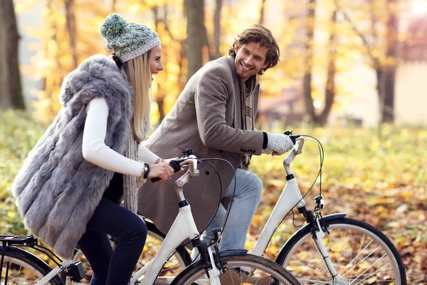 Счастливая пара на велосипедах в лесу осенью — стоковое фото