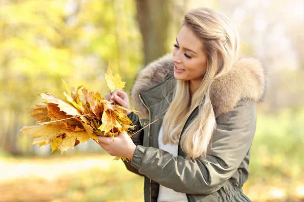 Donna felice che gioca con foglie di autunno all'aperto — Foto Stock