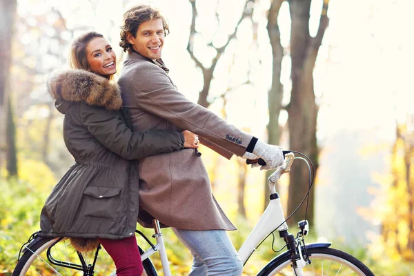 Sonbahar zaman sırasında ormandaki bisiklet üzerinde mutlu çift — Stok fotoğraf