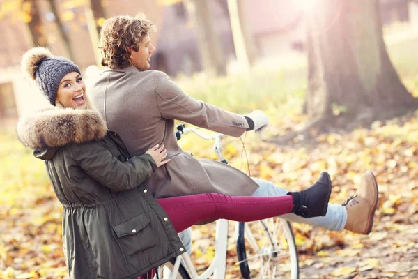 Gelukkige paar op fietsen in het bos tijdens de val tijd — Stockfoto