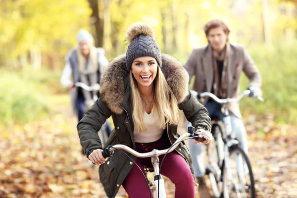 Grupo de amigos en bicicleta en el bosque durante el otoño — Foto de Stock