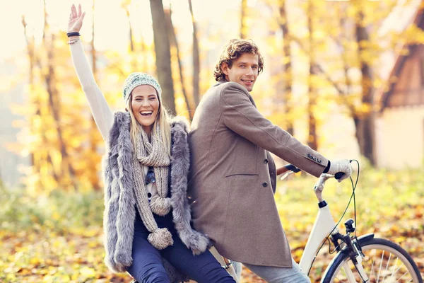 Happy couple on bikes in forest during fall time — Stock Photo, Image