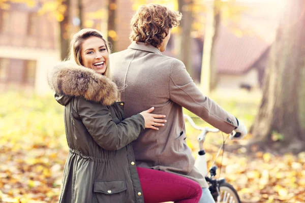 Pareja feliz en bicicleta en el bosque durante el otoño — Foto de Stock