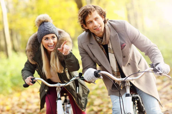 Casal feliz em bicicletas na floresta durante o outono — Fotografia de Stock