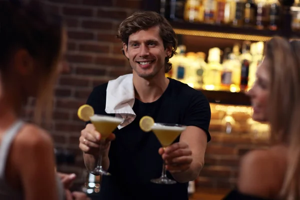 Knappe barman serveert cocktails in een pub — Stockfoto