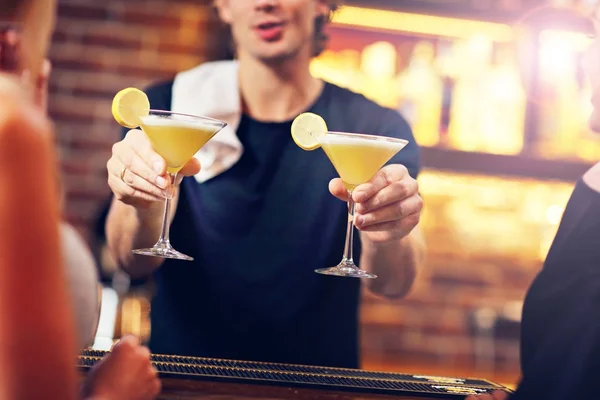 Handsome bartender serving cocktails in a pub — Stock Photo, Image