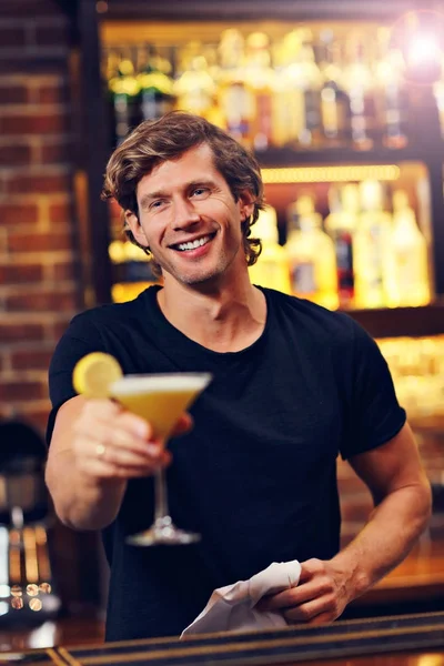 Handsome bartender serving cocktails in a pub — Stock Photo, Image