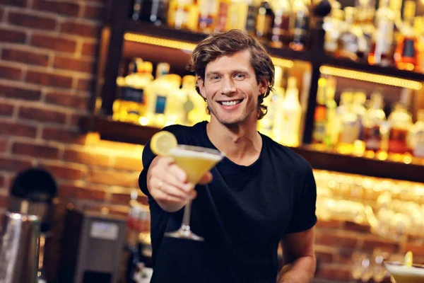 Handsome bartender serving cocktails in a pub — Stock Photo, Image