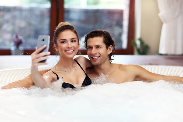 Lyckligt par njuta av jacuzzi i hotellets spa — Stockfoto