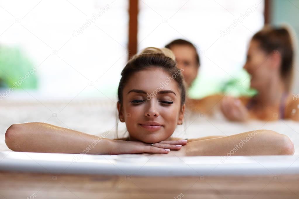 Group of friends enjoying jacuzzi in hotel spa