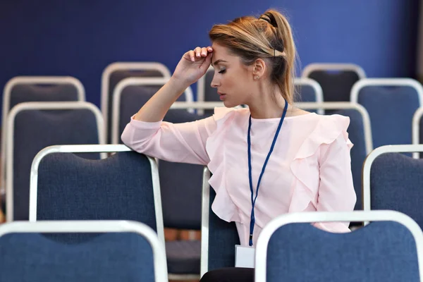 Jeune femme assise seule dans la salle de conférence — Photo