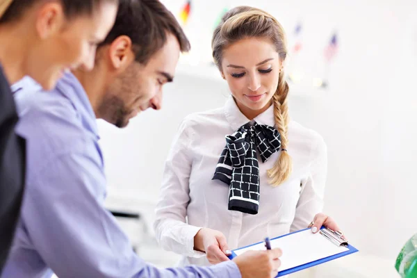 Hotelreceptionist in gesprek met gasten — Stockfoto