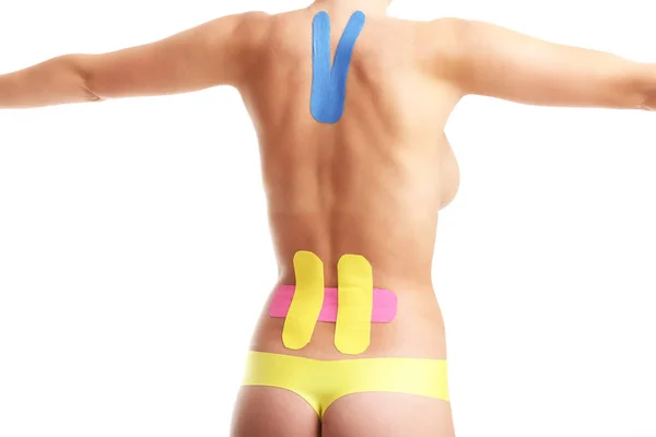 Imagen que muestra la cinta fisiológica especial colocada en la espalda lesionada sobre fondo blanco — Foto de Stock