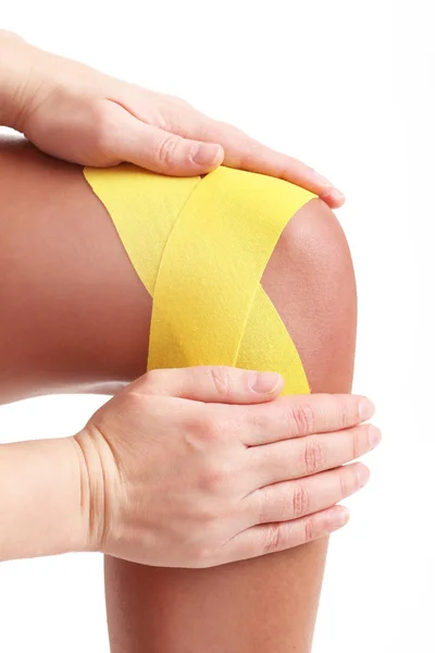 Picture showing special physio tape put on injured knee over white background — Stock Photo, Image