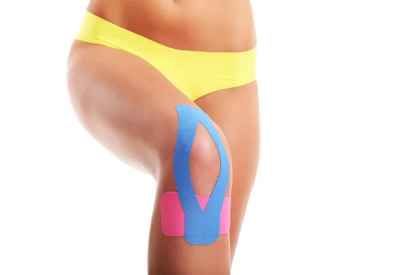 Picture showing special physio tape put on injured knee over white background — Stock Photo, Image