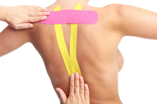 Afbeelding van speciale physio tape zetten gewond terug op witte achtergrond — Stockfoto