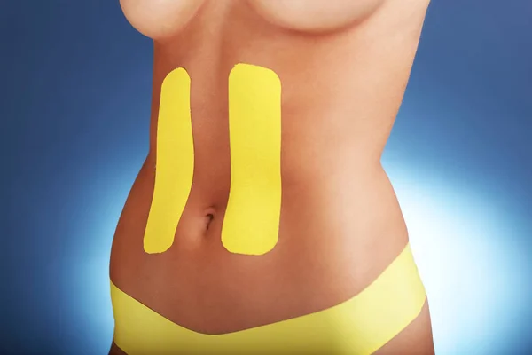 Obrázek ukazující speciální fyzioterapie pásku vložit na poranění břicha nad bílým pozadím — Stock fotografie