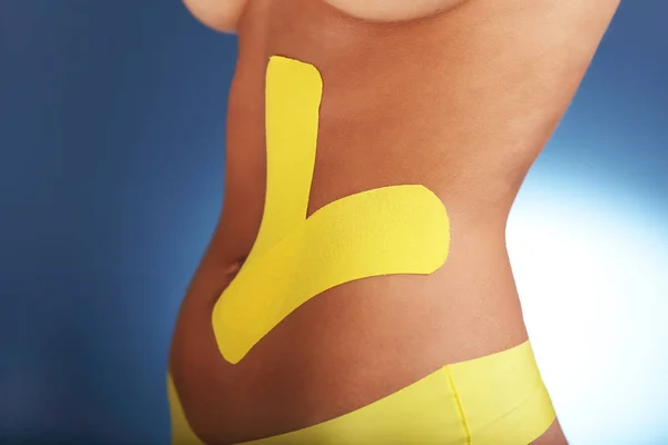 Obrázek ukazující speciální fyzioterapie pásku vložit na poranění břicha nad bílým pozadím — Stock fotografie