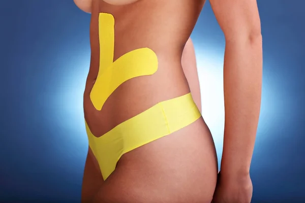 Afbeelding van speciale physio tape zetten op de gewonde buik over witte achtergrond — Stockfoto