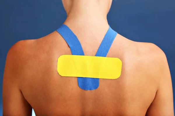Imagen que muestra la cinta fisiológica especial colocada en la espalda lesionada sobre fondo blanco — Foto de Stock