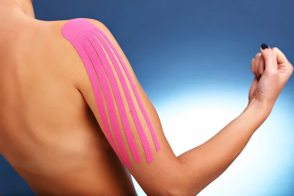 Bilden visar särskilda physio band lägga på skadade arm över vit bakgrund — Stockfoto