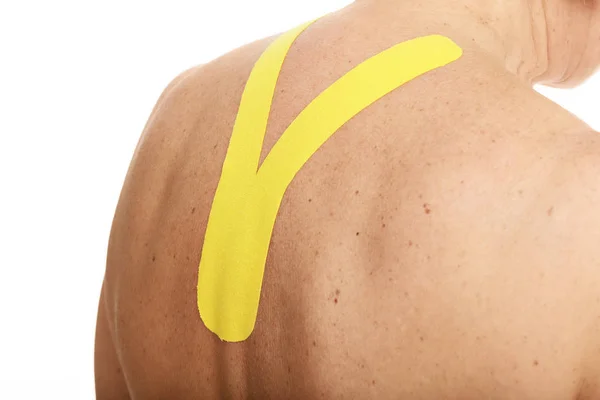 Afbeelding van speciale physio tape zetten gewond terug op witte achtergrond — Stockfoto