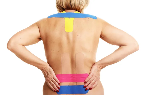 Bild mit speziellem Physioklebeband auf verletztem Rücken vor weißem Hintergrund — Stockfoto