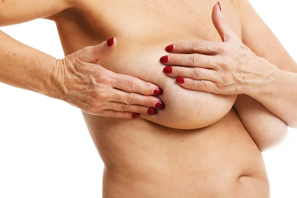 Donna adulta esaminando seno su sfondo bianco — Foto Stock
